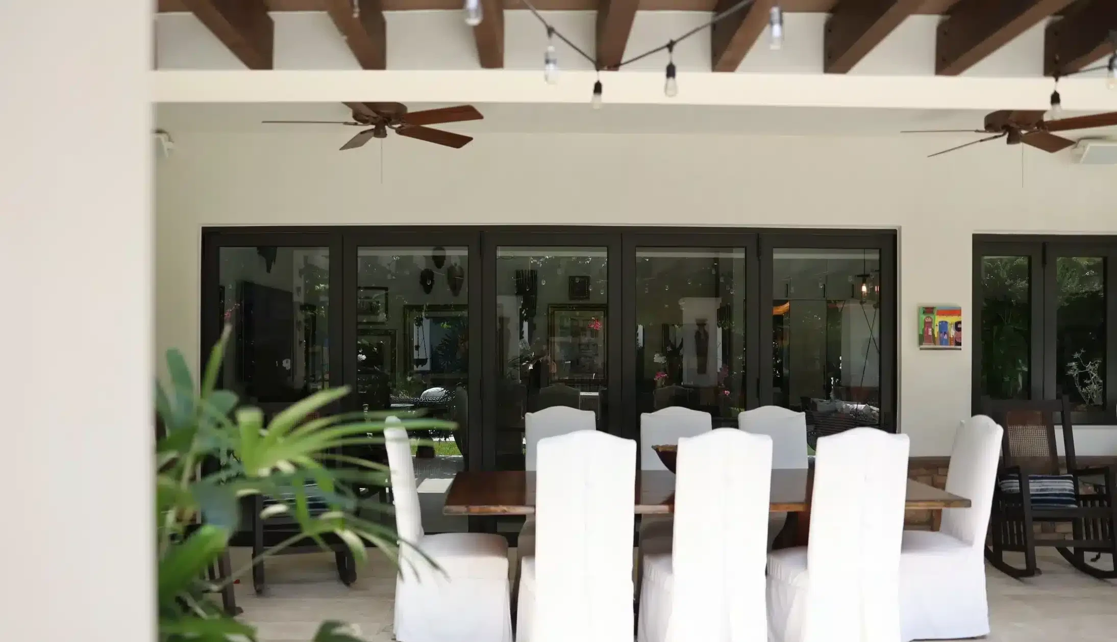 Covered terrace with dark-framed sliding impact doors